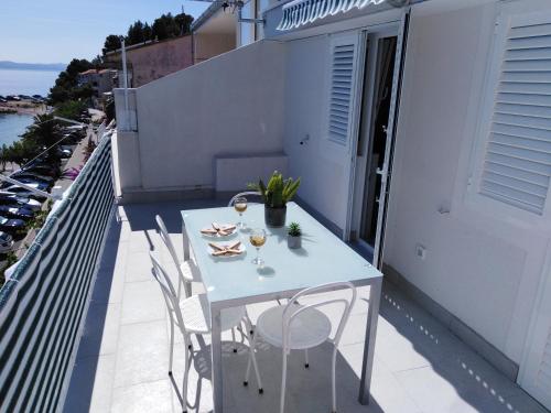伯德古拉Apartment Anđela的阳台上的白色桌子和葡萄酒杯