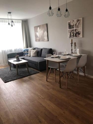 格但斯克Apartament Wejhera Gdańsk Żabianka blisko morza的客厅配有桌子和沙发