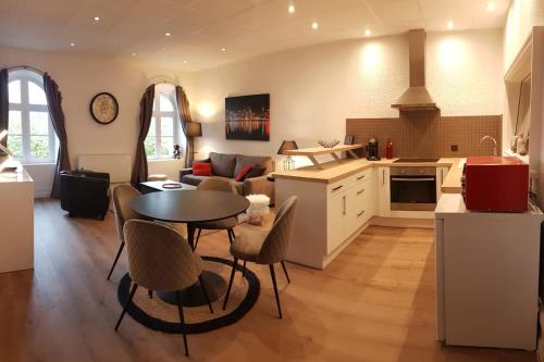 隆勒索涅Appartement vue panoramique, sur les hauteurs de Lons的厨房以及带桌椅的起居室。