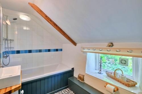 NancledraFinest Retreats - Waterside Cottage的带浴缸和盥洗盆的浴室