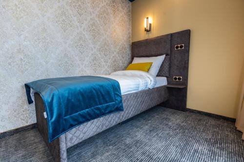 比哈奇HOTEL LOBBY的一间卧室配有一张带蓝色毯子的床