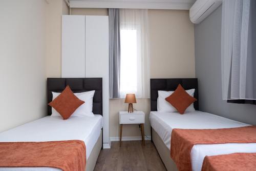 伯萨GREEN SUITES BURSA的一间卧室配有两张带橙色枕头的床
