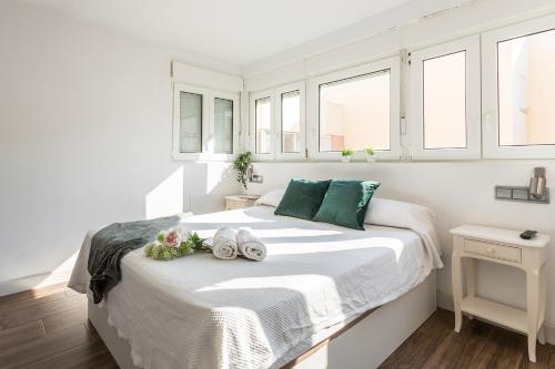 加的斯Ático Avda Cádiz Playa的白色卧室,配有带毛巾的床