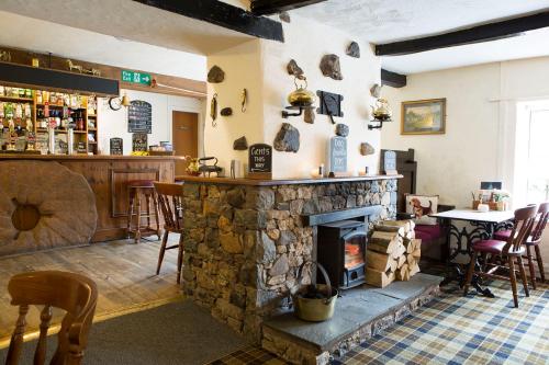 彭里斯The Mill Inn的一间设有石头壁炉和酒吧的客房