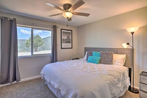 普雷斯科特Prescott Sunset Sanctuary with Panoramic View的一间卧室配有一张带吊扇和窗户的床。