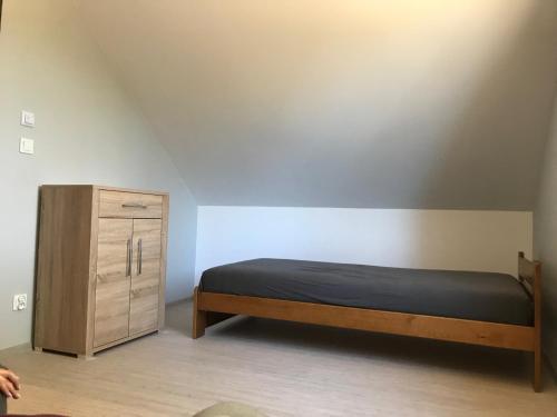 Leśny Domek的一间卧室配有一张床和一个木制橱柜