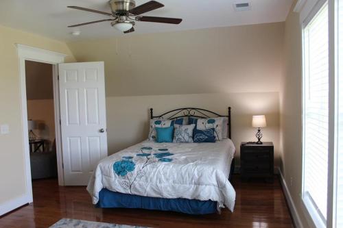 埃迪斯托艾兰Palmetto Hut的一间卧室配有一张带蓝色枕头的床和吊扇