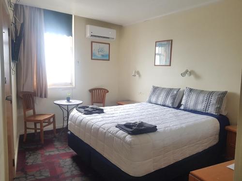 达格维尔Northern Wairoa Hotel的酒店客房,配有带毛巾的床