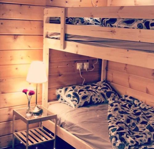 Ash Shishahشاليهات الكوخ السويسري وأكوابارك的一间卧室设有两张双层床和一张带台灯的桌子