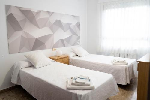 贝纳萨尔APARTAMENTS ROIG的一间带两张床的卧室和几何墙