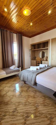 PedhinónVILLA PORTIANOU的一间卧室设有两张床和木制天花板