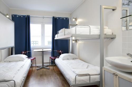 哥本哈根哥本哈根酒店的一间医院间,配有两张双层床和盥洗盆