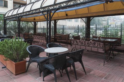 桑丹斯基帕塔利亚家庭酒店的阳台的天井配有桌椅