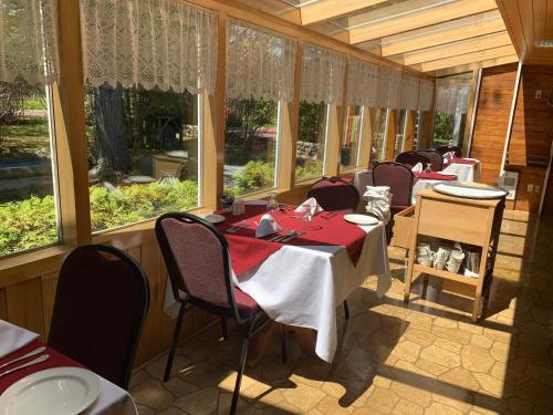 库德尔岛拉罗什普鲁乎斯酒店的用餐室设有桌椅和窗户。