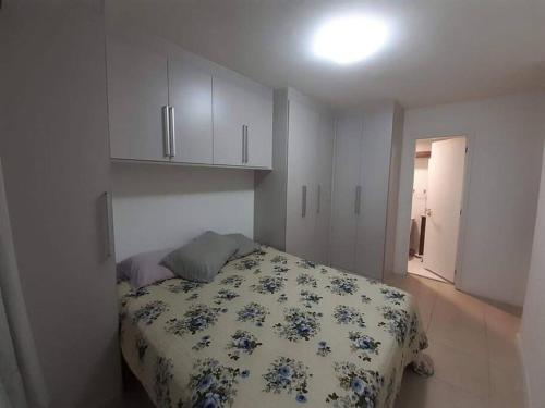 里约热内卢Apartamento Padrão em condominio completo no Recreio的一间卧室配有一张带花卉棉被的床