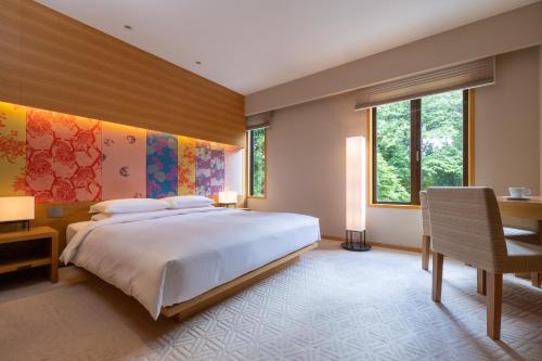 京都京都凯悦酒店的卧室配有一张白色大床和一张书桌