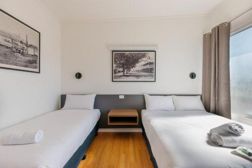 麦凯布姆瑞恩酒店的两张床铺位于一个房间,中间有桌子