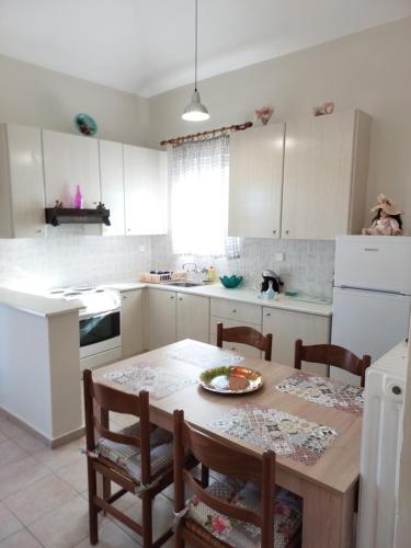 安德罗斯SummerAndros Meliti的厨房配有一张木桌、椅子和一盘食物