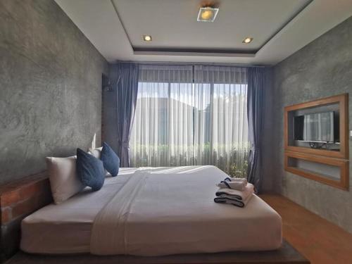 查龙BaanMee Phuket SHA Plus的一间卧室设有一张大床和大窗户