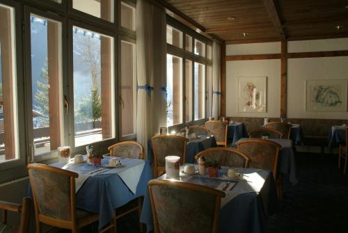 格林德尔瓦尔德里斯登公寓酒店的用餐室设有桌椅和窗户。
