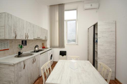 库塔伊西Hostel Mandaria的白色的厨房配有桌子和水槽