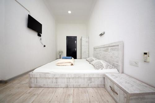 库塔伊西Hostel Mandaria的一间白色卧室,配有床和电视