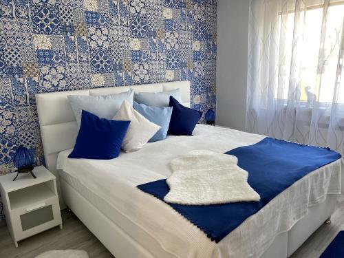 奥尔珀Ferienwohnungen Schimsheimer Rhode的一间卧室配有一张带蓝色和白色枕头的床