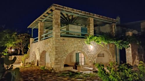 安倍拉斯Nikolas Villa的一座石头房子,晚上有拱门