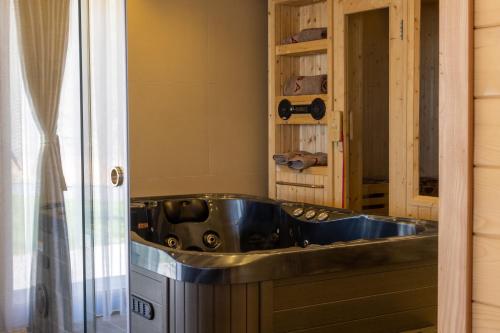 OrllanBatllava Premium Resort Villa 1的一间位于客房内的带钢浴缸的浴室