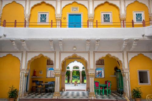 斋浦尔Diggi Palace - A City Center Hidden Heritage Gem的建筑中的一个拱门,有黄色的墙壁