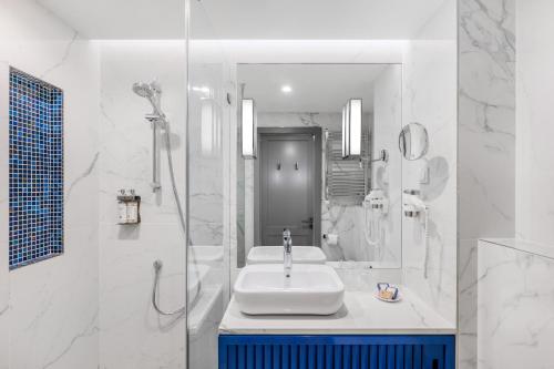布达佩斯阿斯托瑞亚市中心丹比乌斯酒店的白色的浴室设有水槽和淋浴。