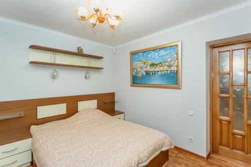 基希讷乌Bright and cozy home with personal terrace的卧室配有一张床,墙上挂有绘画作品