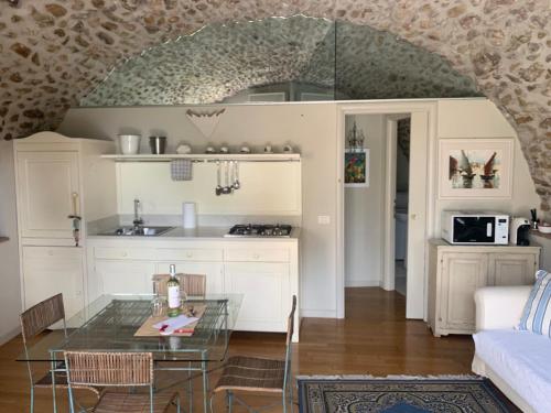 明乔河畔的瓦雷奇奥La Guarnigione的厨房以及带玻璃桌的起居室。
