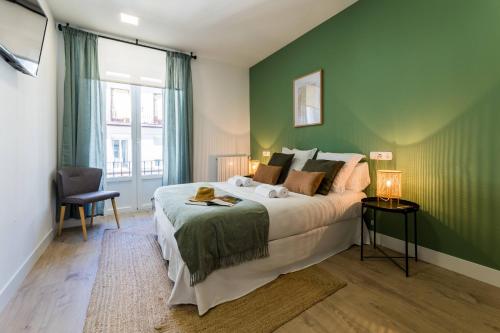 圣塞瓦斯蒂安GETARIA SUITE Apartment的一间卧室设有一张大床和绿色的墙壁