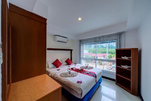 奥南海滩Krabi Apartment-SHA Extra Plus的一间卧室设有一张床和一个大窗户