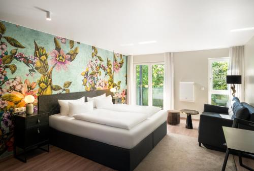 卡尔斯鲁厄ANA Living Karlsruhe by Arthotel ANA的一间卧室设有一张床和一间客厅。