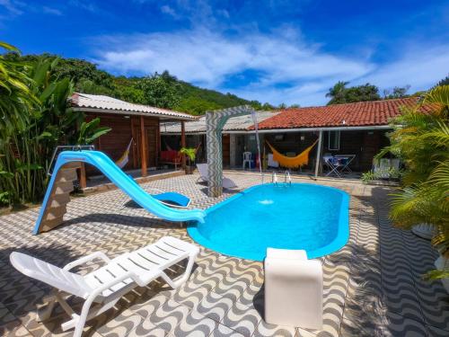 费尔南多 - 迪诺罗尼亚Pousada das Flores的一个带滑梯和游泳池的后院