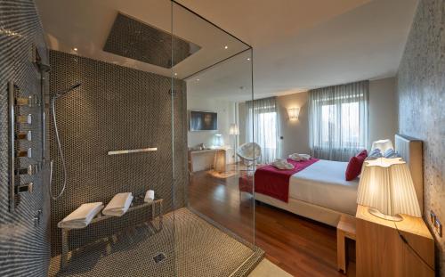 SandiglianoRelais Santo Stefano的一间卧室设有一张床和一个玻璃淋浴间