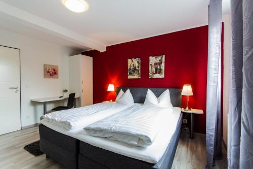 弗雷登Hotel Zum Jägerhaus的一间卧室设有一张红色墙壁的大床