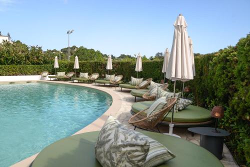 罗列特海岸BPM Lloret Hotel的游泳池配有躺椅和遮阳伞