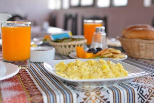 库斯科SQ Hotel del Inca的一张桌子,上面放着一盘炒鸡蛋和橙汁