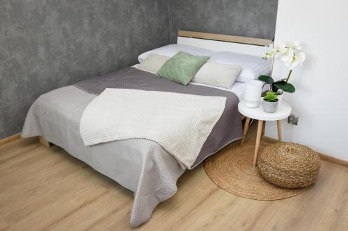 奥斯威辛Apartamenty Legionów 30的一间卧室配有一张床和一个带桌子的床头柜