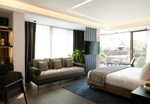塞萨洛尼基Teight Hotel的一间卧室配有一张床、一张沙发和一把椅子
