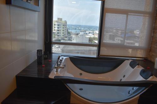 曼塔HOTEL OCEANIK的带浴缸的浴室和大窗户
