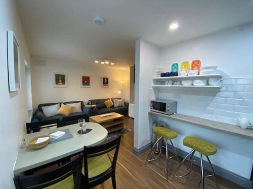 基拉尼Location Location - Gorgeous 3 Bed Apartment in Killarney的厨房以及带桌椅的起居室。