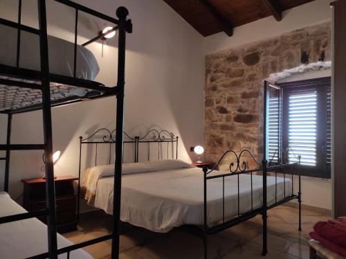 阿尔布斯Agriturismo Gragonti, Arbus Costa Verde的一间卧室设有两张双层床和石墙