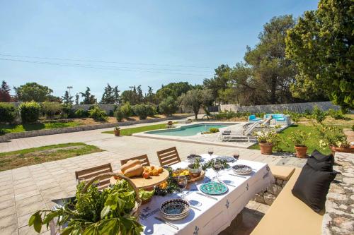 科斯基努Emarmene Home with private pool near Rhodes Town & airport的一张桌子,上面有食物,坐在庭院里