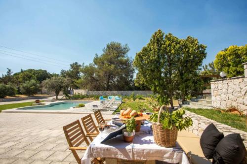 科斯基努Emarmene Home with private pool near Rhodes Town & airport的池畔露台配有桌椅