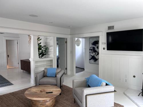 洛杉矶The Craftsman House in Venice Beach的客厅配有2把椅子和平面电视