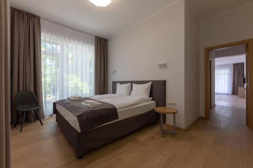 尤尔马拉Oasis Apartments的一间卧室设有一张床和一个大窗户